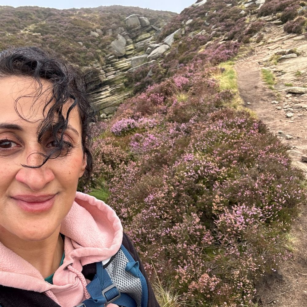 A lady walking amongst rocks and heather